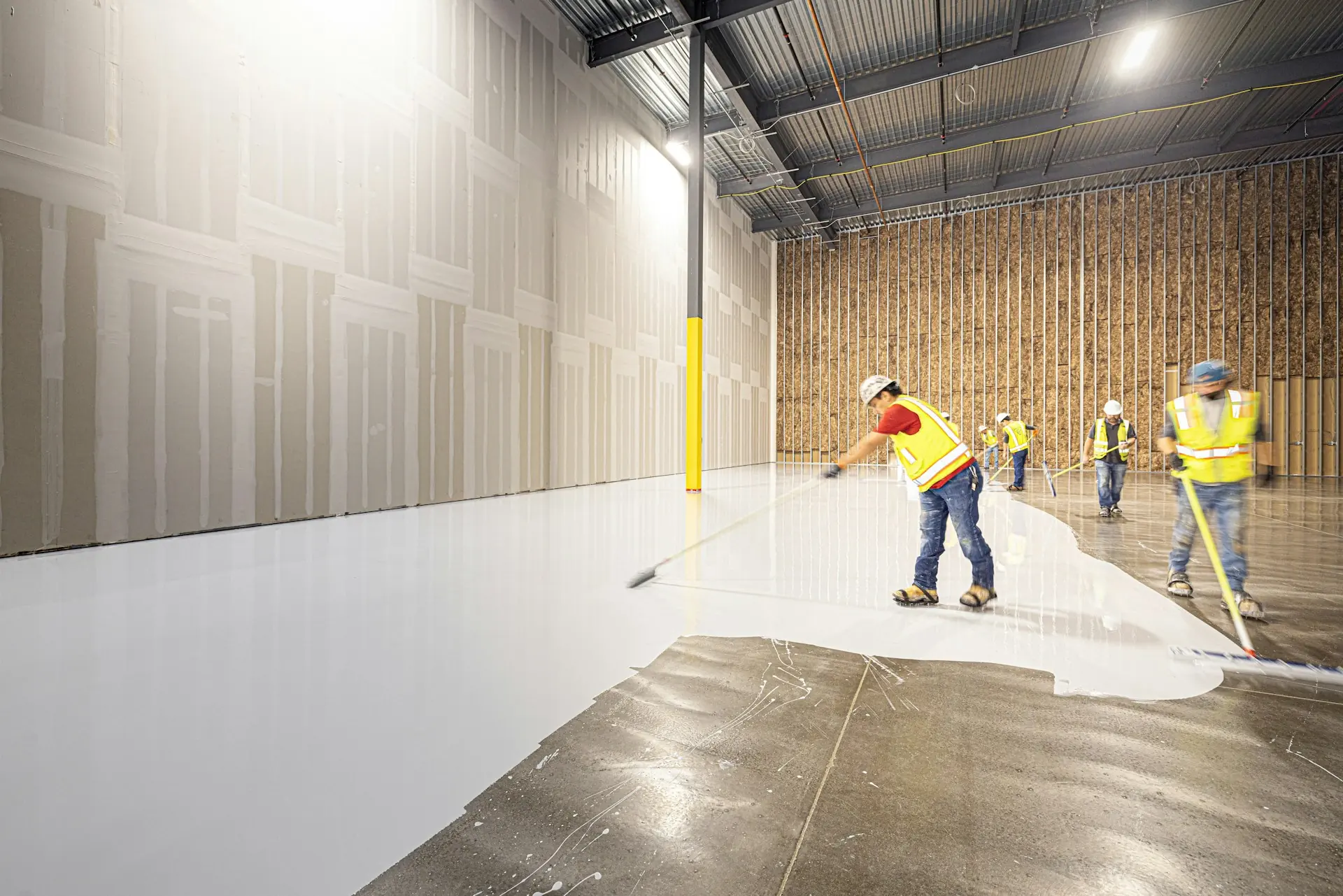 Crew coating a large warehouse floor
