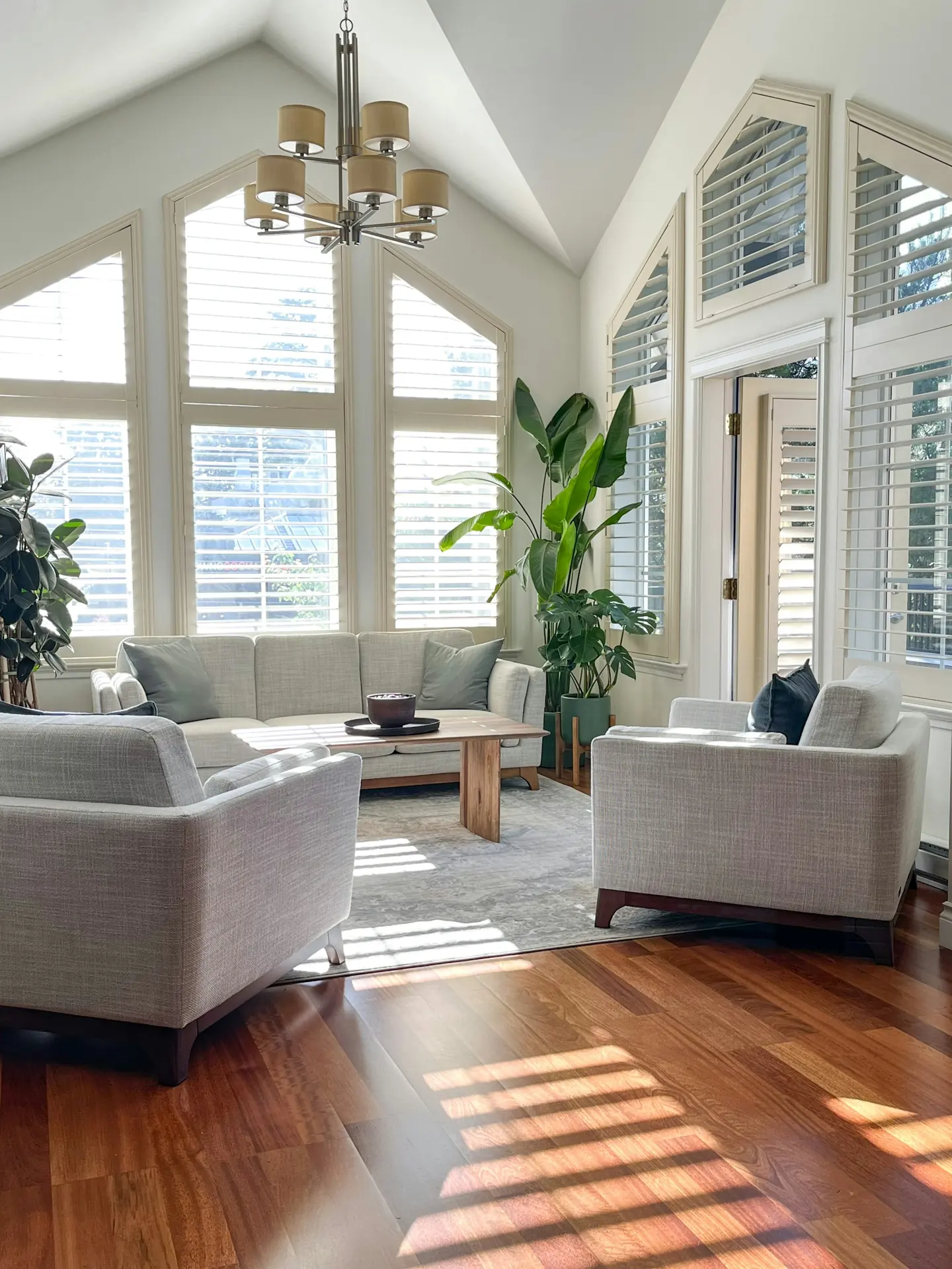 Bright living room with vaulted ceiling, white walls and tall windows