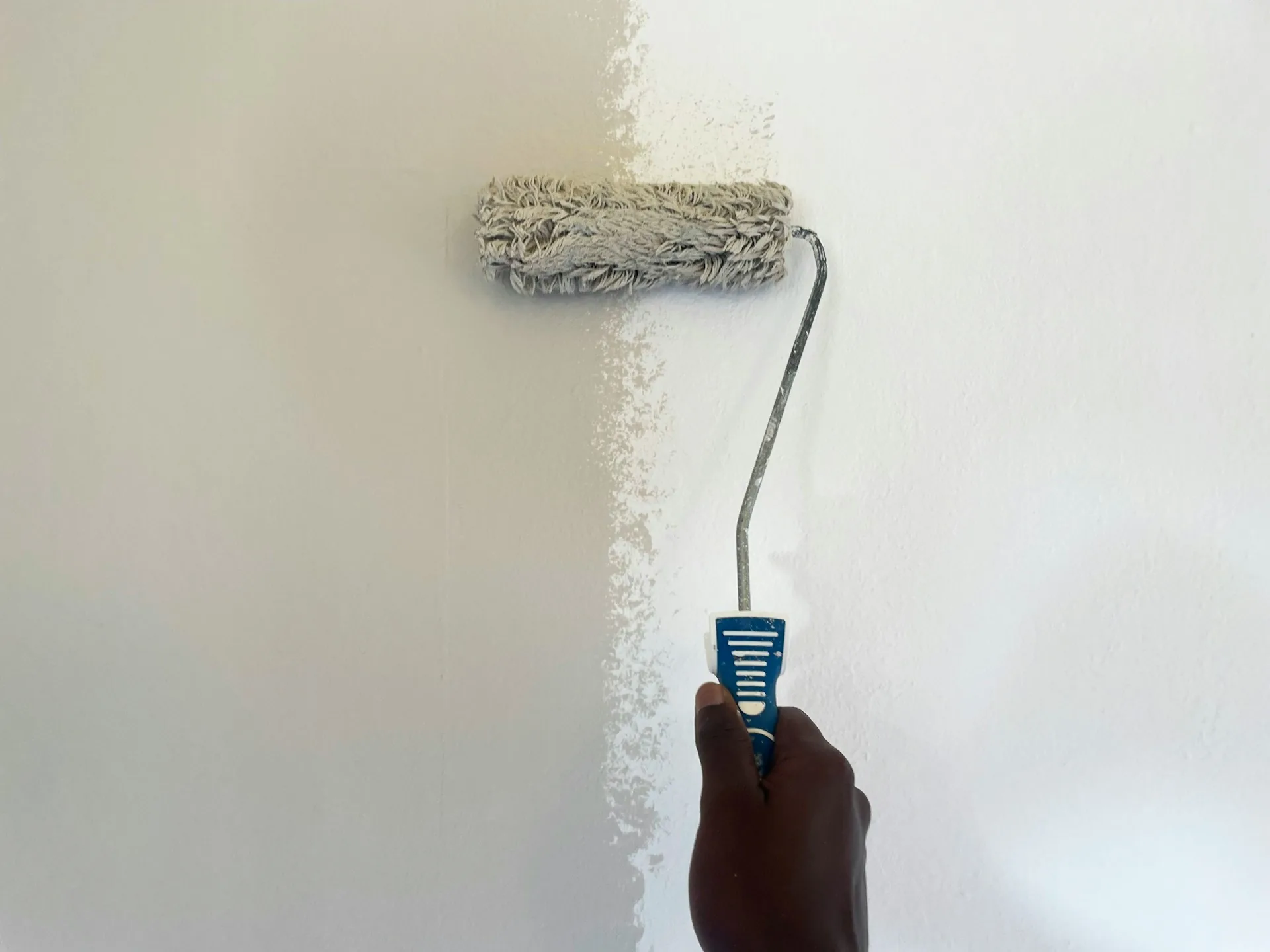 Painter rolling a fresh coat onto an interior wall